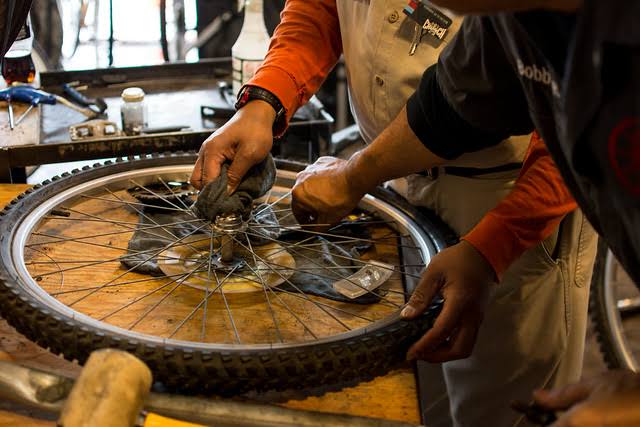 Bicycle mechanic performing a detailed repair with professional tools